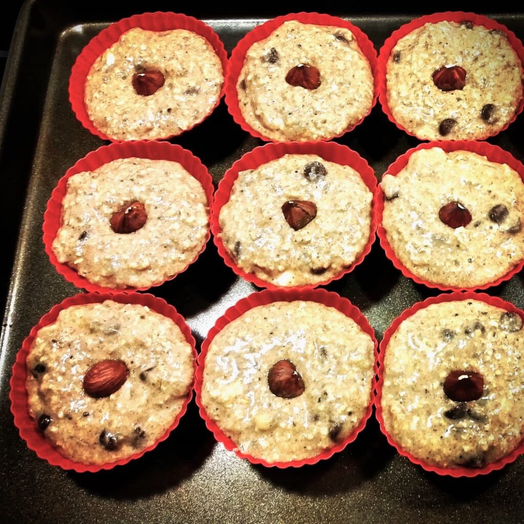 Cottage in the Sky: Spoon muffin dough into each silicon baking cup and place a hazelnut on top.